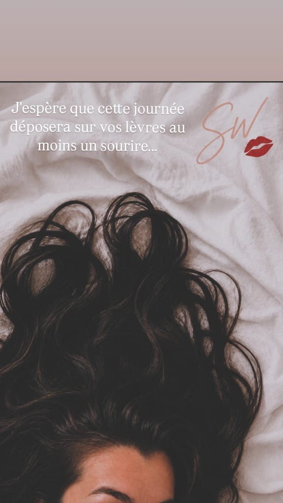 Drap blanc froissé avec une chevelure noire ondoyante, un visuel de lèvres rouges et une citation en français, plus la signature “SW💋” de @sarahwhisper.
