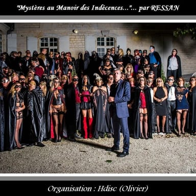 Photo de groupe en extérieur devant un bâtiment en pierre, avec le texte « Mystères au Manoir des Indécences… » et « Organisation : Hdisc (Olivier) » pour @HDISC.